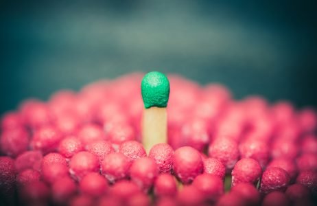 图片:木制比赛,绿色顶部从一群木制比赛中脱颖而出,红色上衣