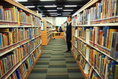 图像:一个公共图书馆的过道,两侧是书架。