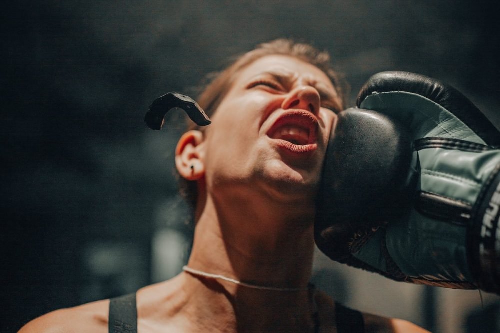 图片:一名女拳击手被打了一拳,送她的防护口挡住了空气。