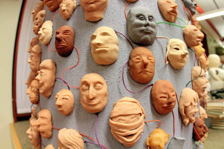图像：连接到一列的许多面孔的雕塑，全部通过彩色线相互连接。