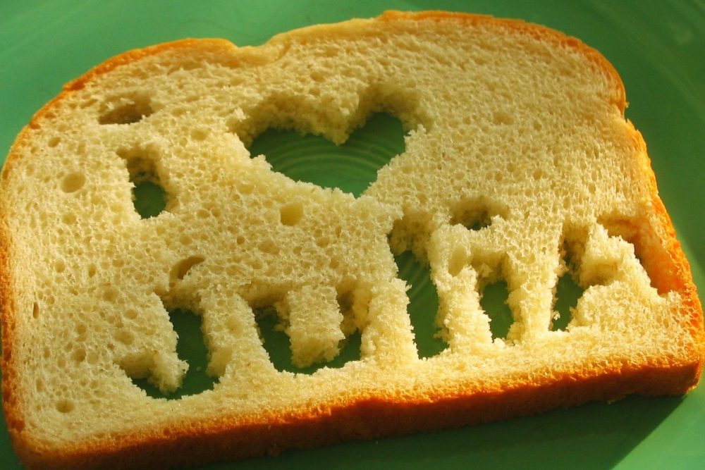 图像：在绿色盘子上是一片白面包，从中切开了“ I Heart Julia”的咒语。