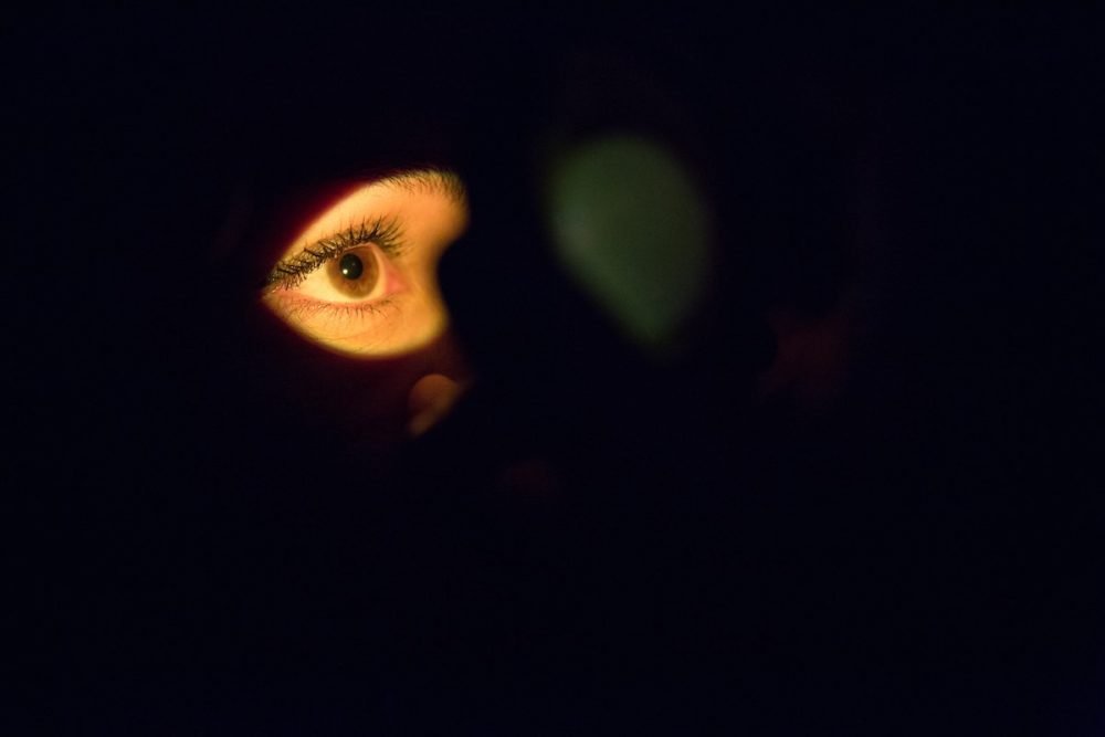 图像：在黑暗的空间中，光线照亮了女人的眼睛。