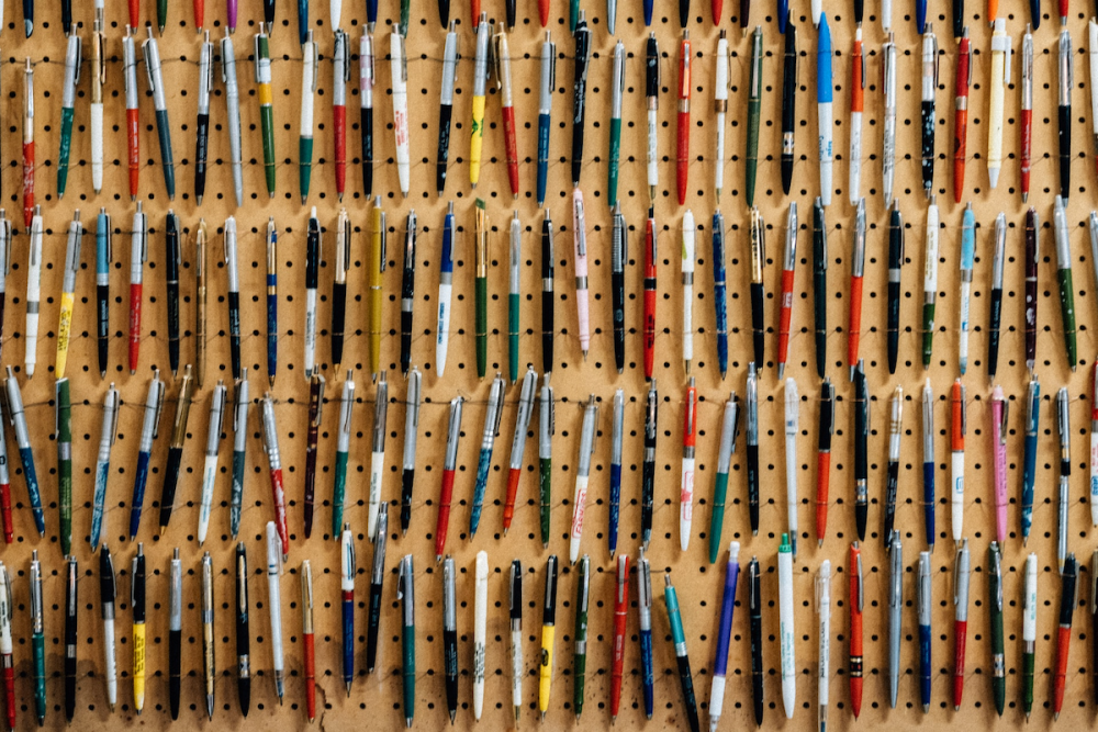 图片:墙上的钉板，表面挂着数百支不同的圆珠笔。