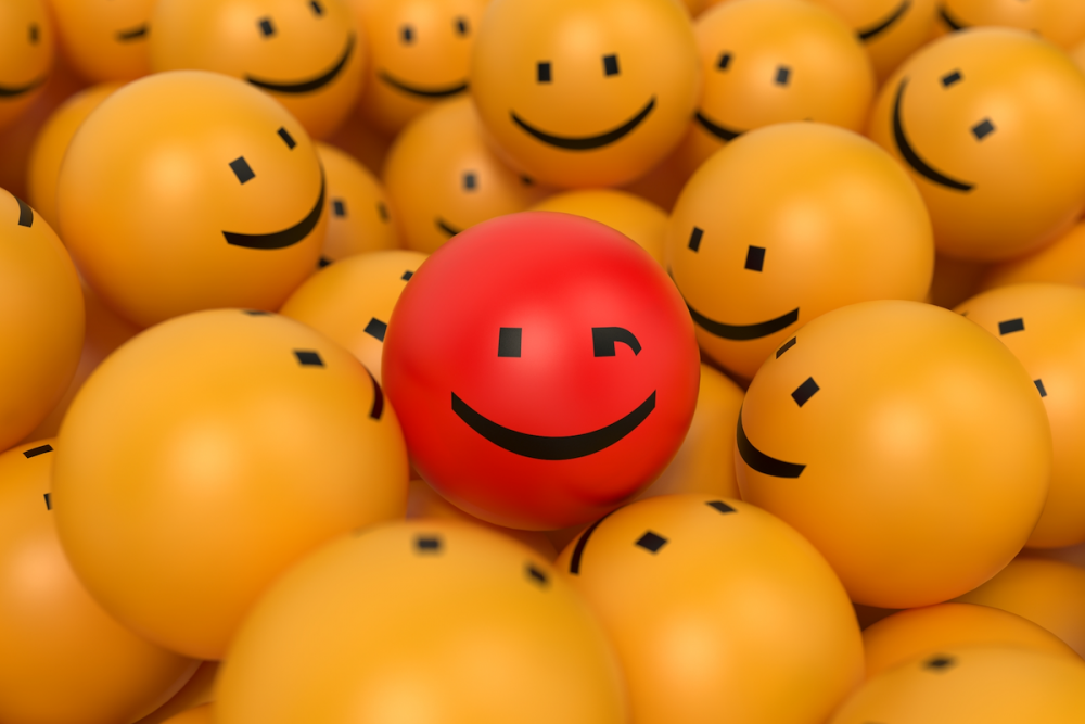 图片:在一堆黄色笑脸球的中央，有一个红色笑脸球。