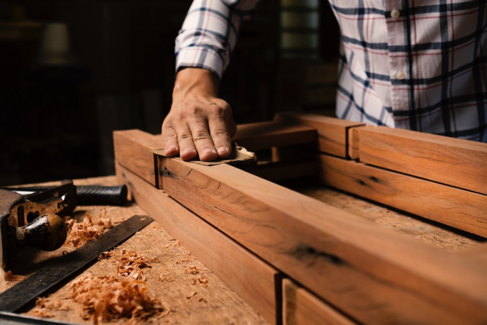 图片:一个木工在他的店里打磨一个项目。