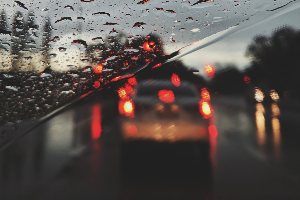图片:英国高速公路上汽车的观点通过一个下雨的挡风玻璃在黎明时分。