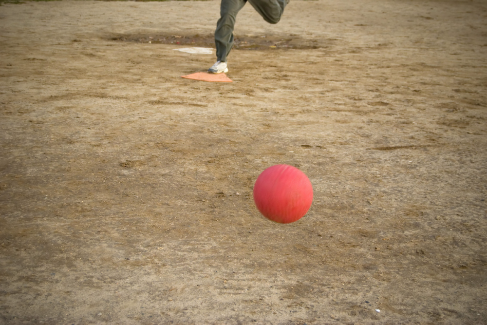 图片:竞技场,一个红色的踢球投掷向的人准备踢它。