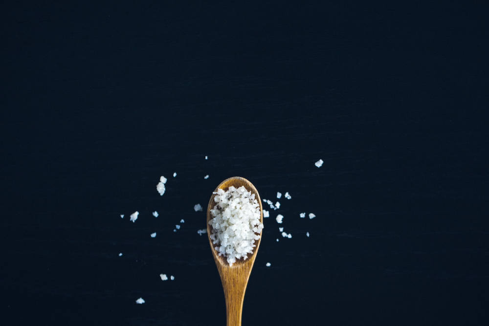图片:一个小木勺控股谷物的盐。